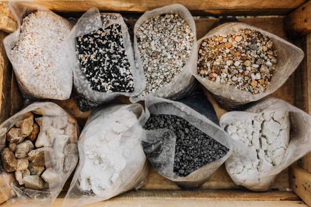 Top view of assorted pebbles and stones in bags within a wooden crate.